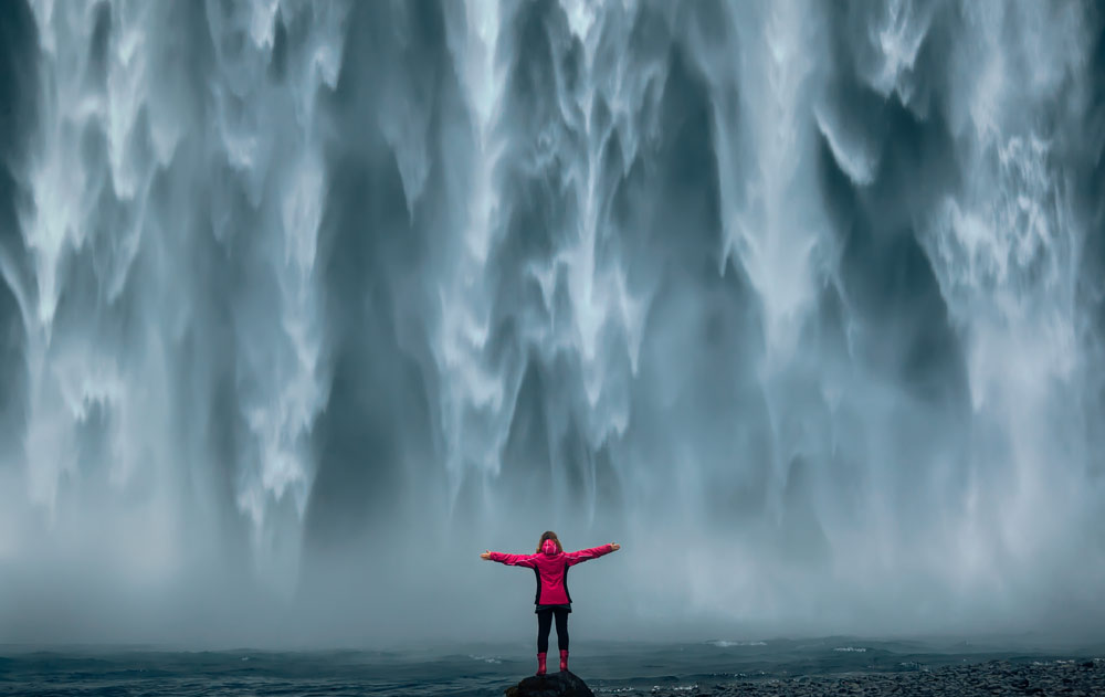 Frau posiert vor Skogafoss Wasserfall in Island